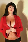 Busty Rachel Aldana poses in a corner with her sexy red top