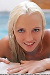 Beautiful blonde teen Alysha undresses and swims in the pool