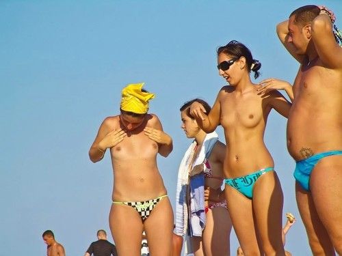 Stripped adolescent princesses take part in equally at a public beach