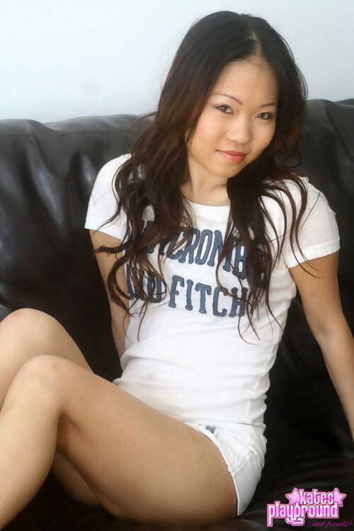 Alluring Chinese pretty removes clothes to her brassiere and underclothing on a leather ottoman