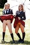 Adolescent schoolgirls Cali Sparks and Kelly Greene tongue giving a kiss outdoors