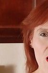 Redhead adult Debra is lying as was born on the floor and playing with dick